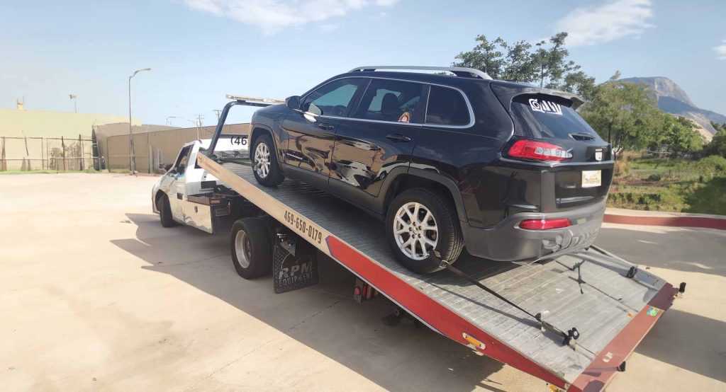 suv on the back of a tow truck