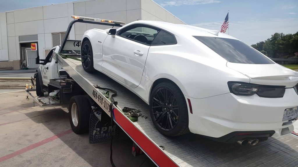 white sports car on the back of a tow truck