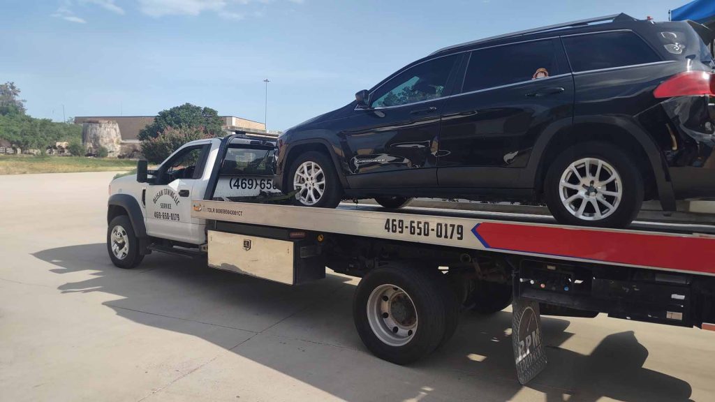 suv on the back of a tow truck