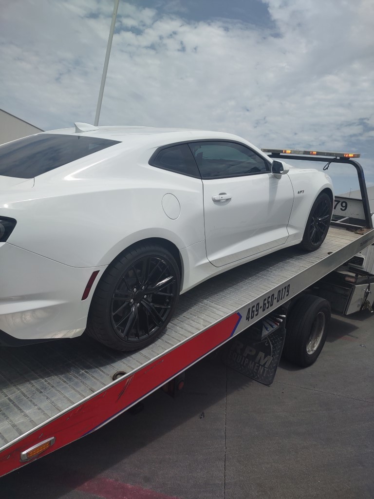 white sports car on a flatbed trailer